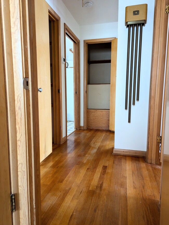 The hardwood hallway offers two closets and a laundry chute. - 910 Maple St