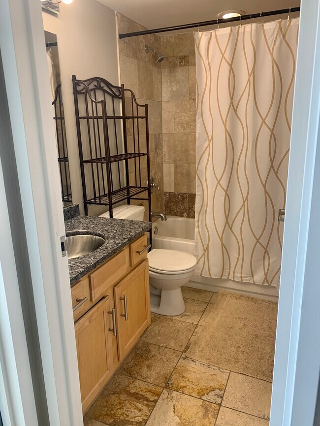 Full guest bath with tub and built in shelves. - 700 E 8th St