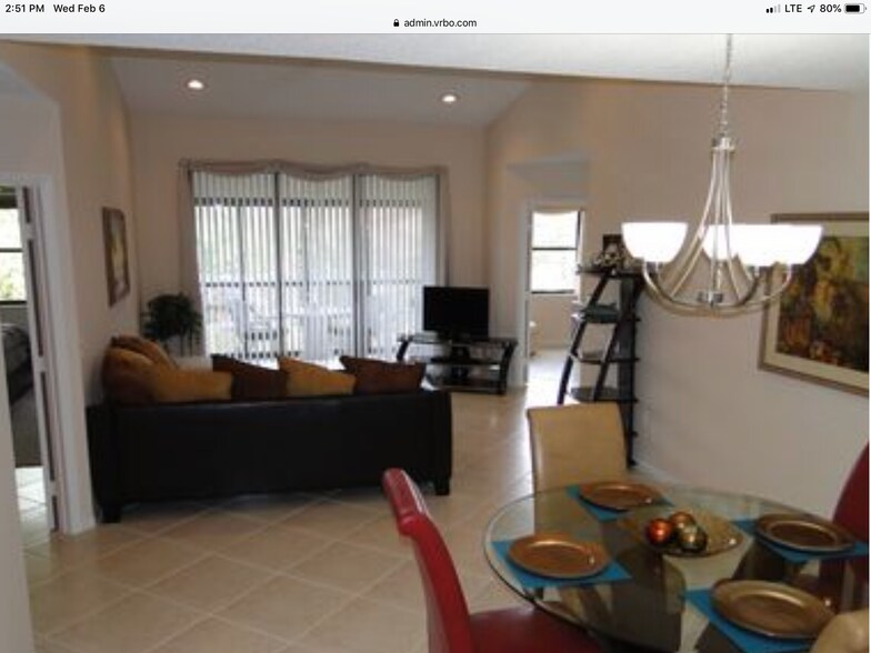 Living and Dining Area with recessed lighting, vaulted ceiling, and view of pond. - 5265 Brisata Circle
