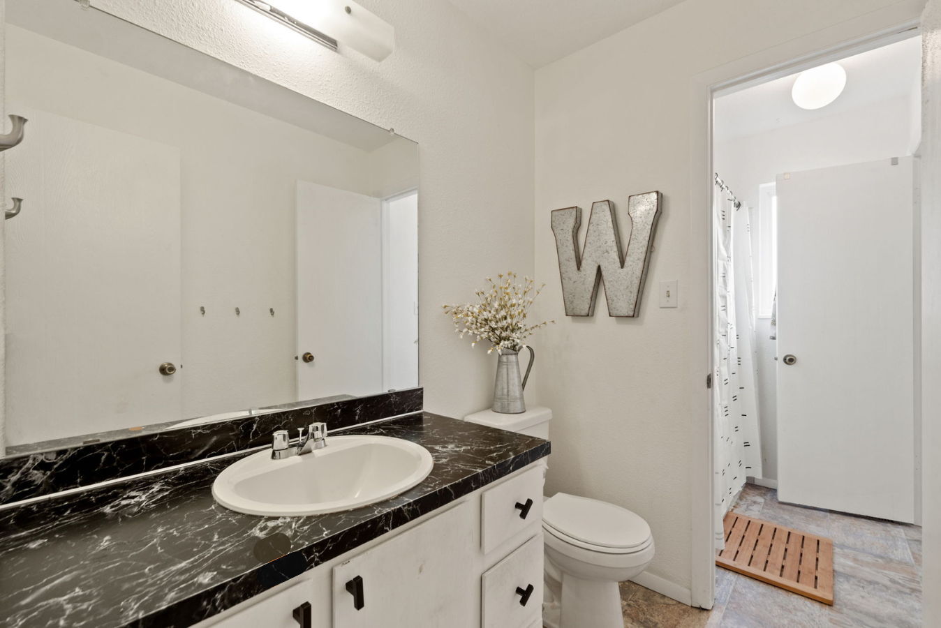 Bathroom with fixtures and shower/tub in the background.. - 3418 Stratton Dr