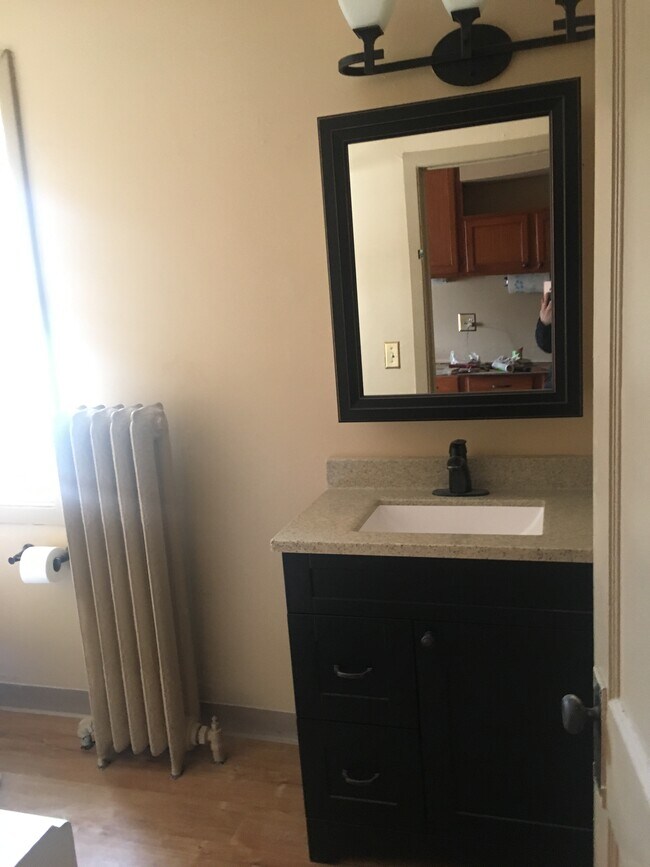 The bathroom is just past the dining room, with a one piece quartz vanity, new in 2019 - 3452 Nicollet Ave