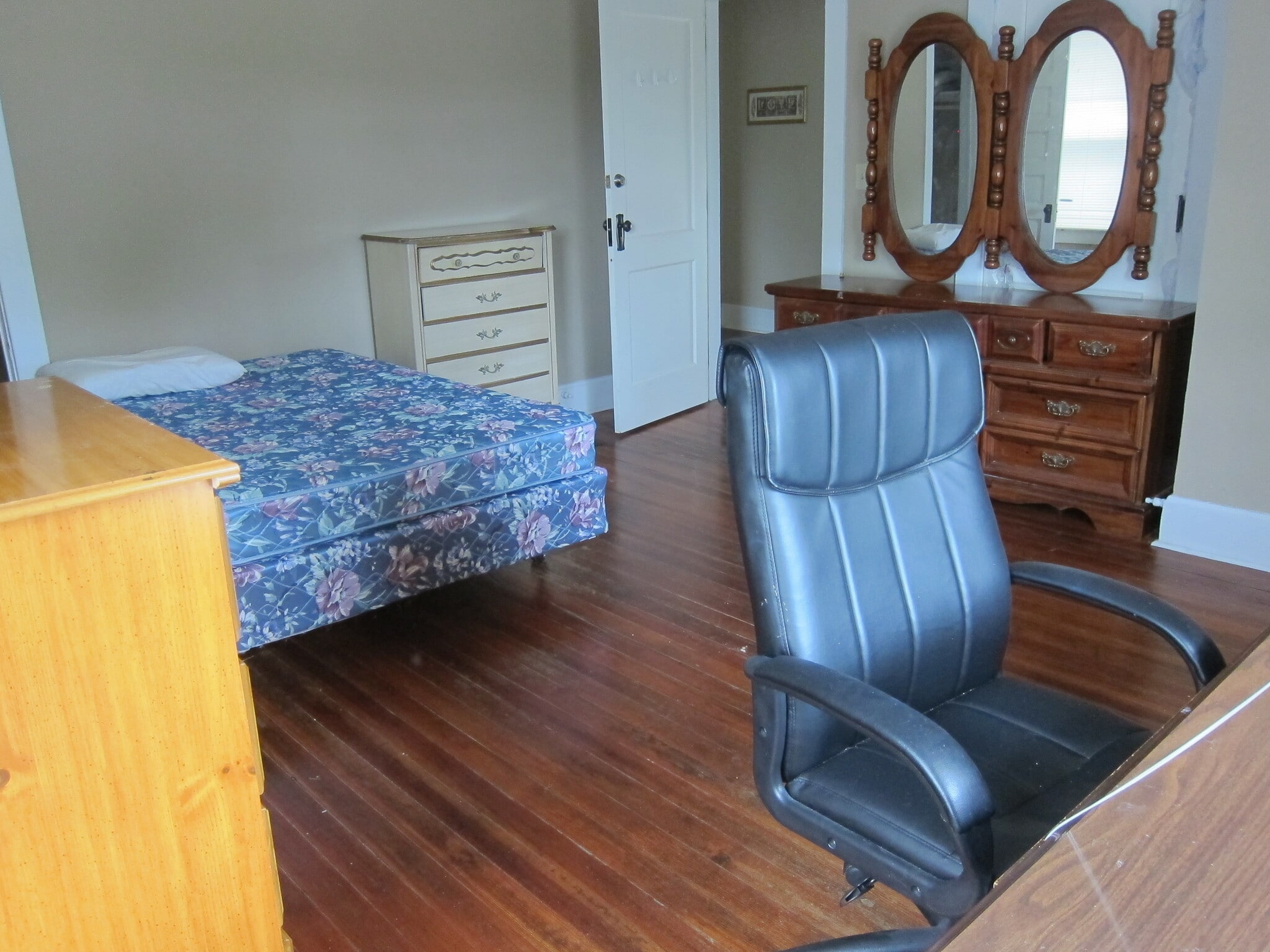 The bedroom as seen from the southeast toward the door. The desk, mirror, queen bed and dresser are included. The white and maple dressers are not included, just the walnut one. - 1525 South 7th Street