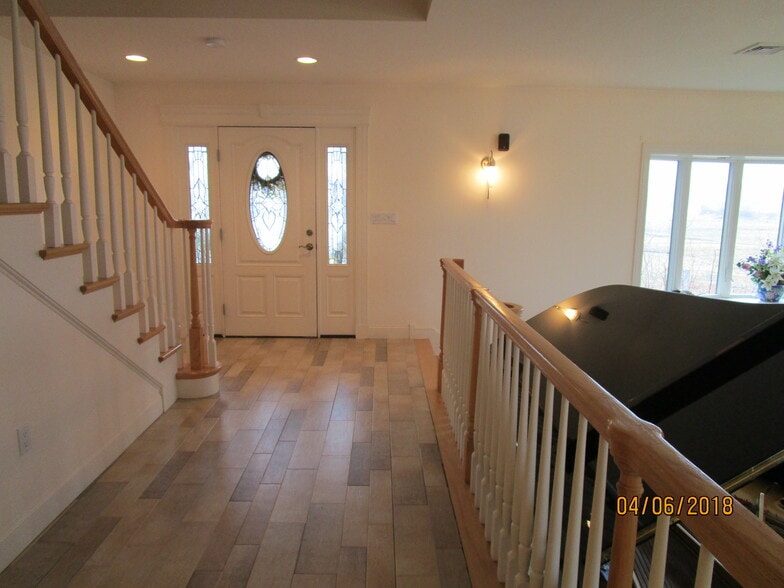 front entryway, stairs to bedroom floor on left, steps to sunken living room on right - 103 Summer St