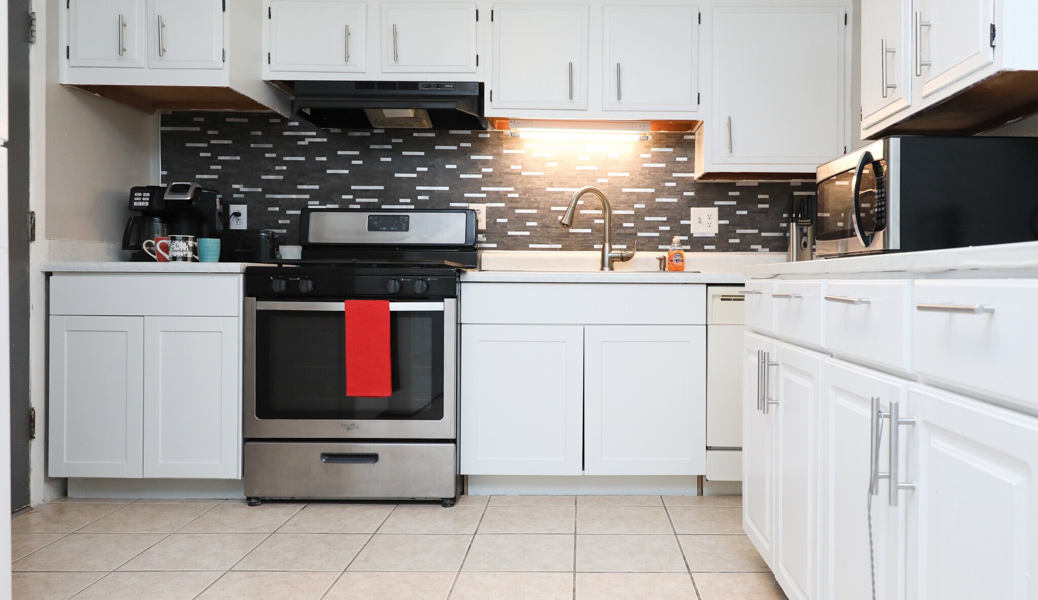 Stainless steel and black stove, microwave and coffee maker. - 8612 Echo St