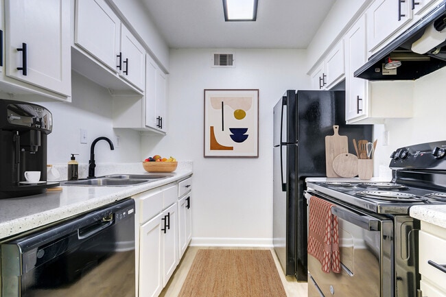 A contemporary kitchen with black appliances and black finishes is shown. - ReNew on Cantrell