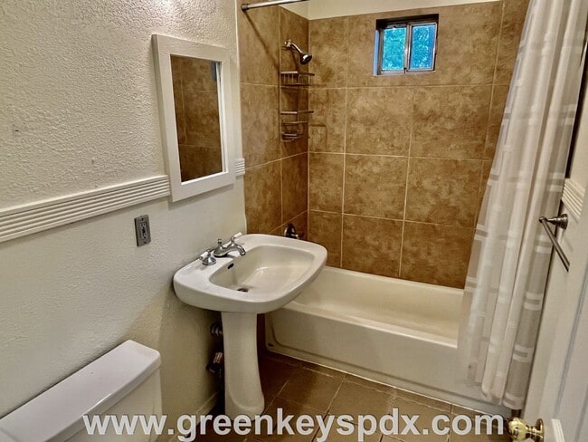 Building Photo - This 3-bedroom 1-bathroom house has a large front yard and a mostly fenced backyard.