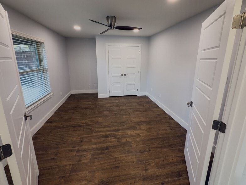 Bedroom with ceiling fan, natural light, and double closet doors - 2006 Candle Ct