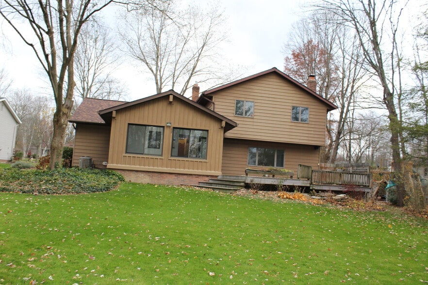 Large tree-lined backyard with spacious deck for outdoor dining and entertaining. - 6235 Sunnywood Dr