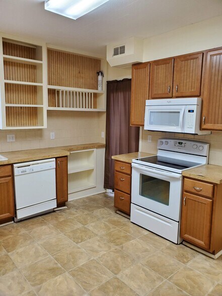 Kirchen with view of cooking area, dishwasher, built-in plate holder and a mix of open and closed cabinetry. Curtain "door" is to mechanical room (furnace and hot water heater) - 607 Harrison Ave