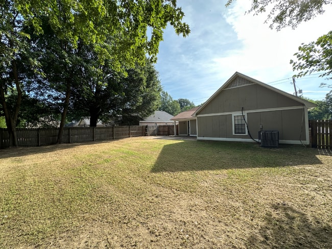Building Photo - Charming 3BR/2BA Near Southwind | Soaring Vaulted Ceilings, Brick Fireplace & Fenced Yard