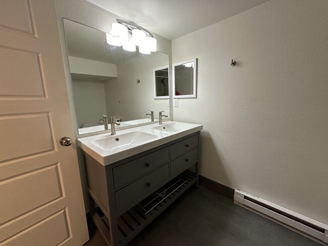 Updated bathroom with double sink vanity and shower - 1137 E Platte Ave