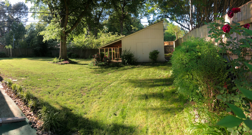 View of the back yard and storage shed. Lawn care is also included in the back. To the left, there is a covered outdoor patio that can fit a full outdoor seating set. - 4968 New Haven Ave