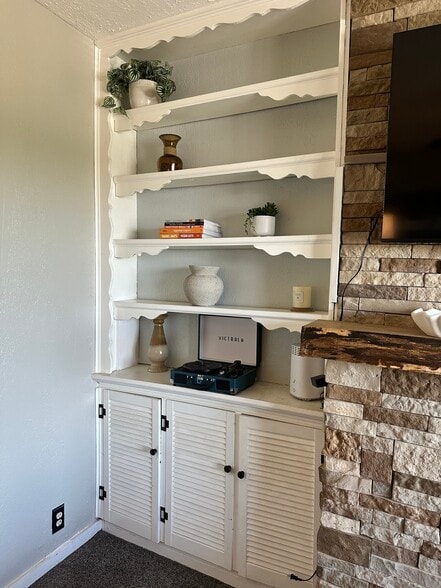 Bright living room with stone fireplace and built-in shelving - 2328 Primrose St