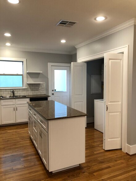 In unit washer and dryer with tankless water heater in storage closet offsetting kitchen. - 1712 Blodgett St