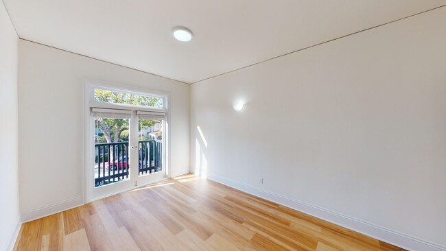 Sunlit room with a large window and wood-like flooring - 1729 Arch Street