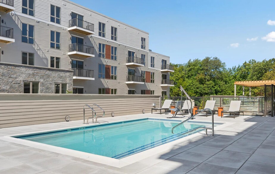 Resort-style pool with sundeck and chaise lounges. - Modera Newton