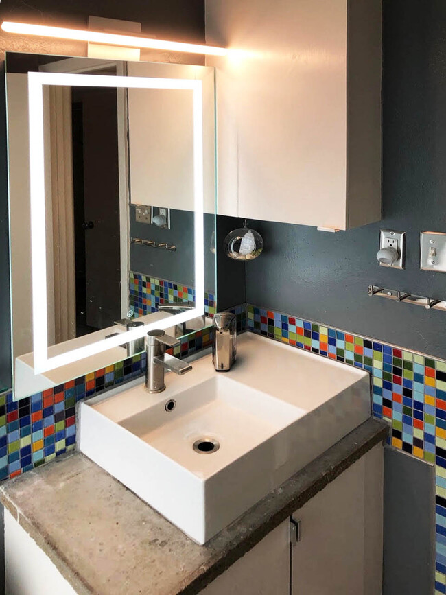 Bathroom sink detail, backlit mirror and bitmap color tile - 1602 Valleyridge Dr