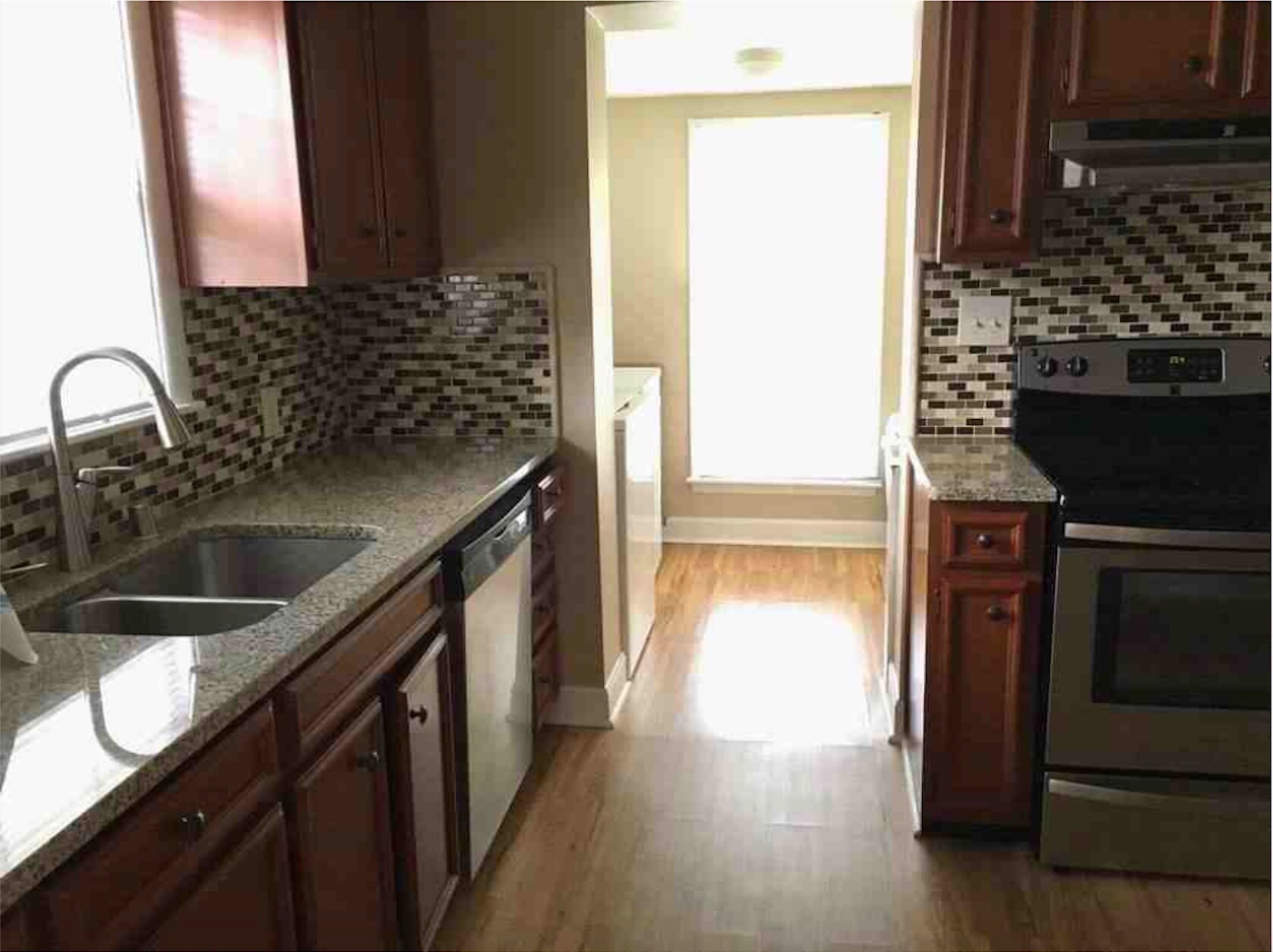 Gorgeous eat-in kitchen featuring granite countertops, custom cabinetry, stainless appliances, mosaic tile backsplash, and hardwood floors. - 2325 Broadmeade Road