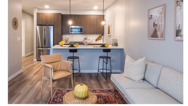 Spacious living room with open concept designer kitchen, espresso cabinetry, and stainless steel appliances - Modera LoHi