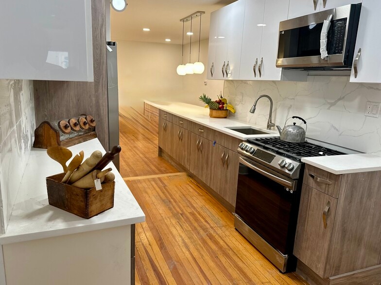 Newly renovated kitchen with stainless steel appliances, original wood floors, and generous storage. - 328 High St