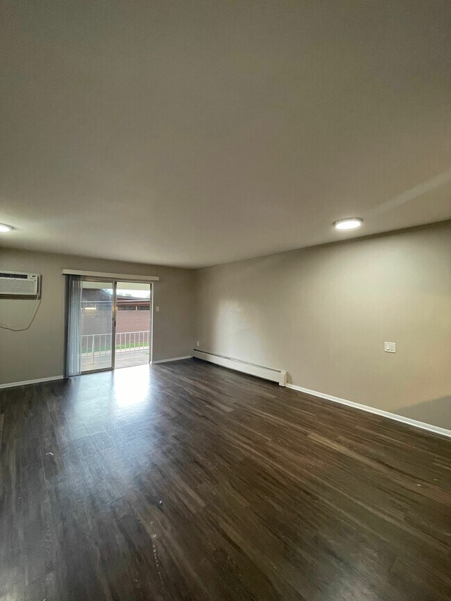 Experience the openness and warmth of this roomy living space, perfect for relaxation. - GRACE LANDINGS APARTMENTS