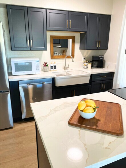 Kitchen with farmhouse sink, microwave, new cabinets, countertops, dishwasher, Keurig coffee maker. - 1795 W 28th St