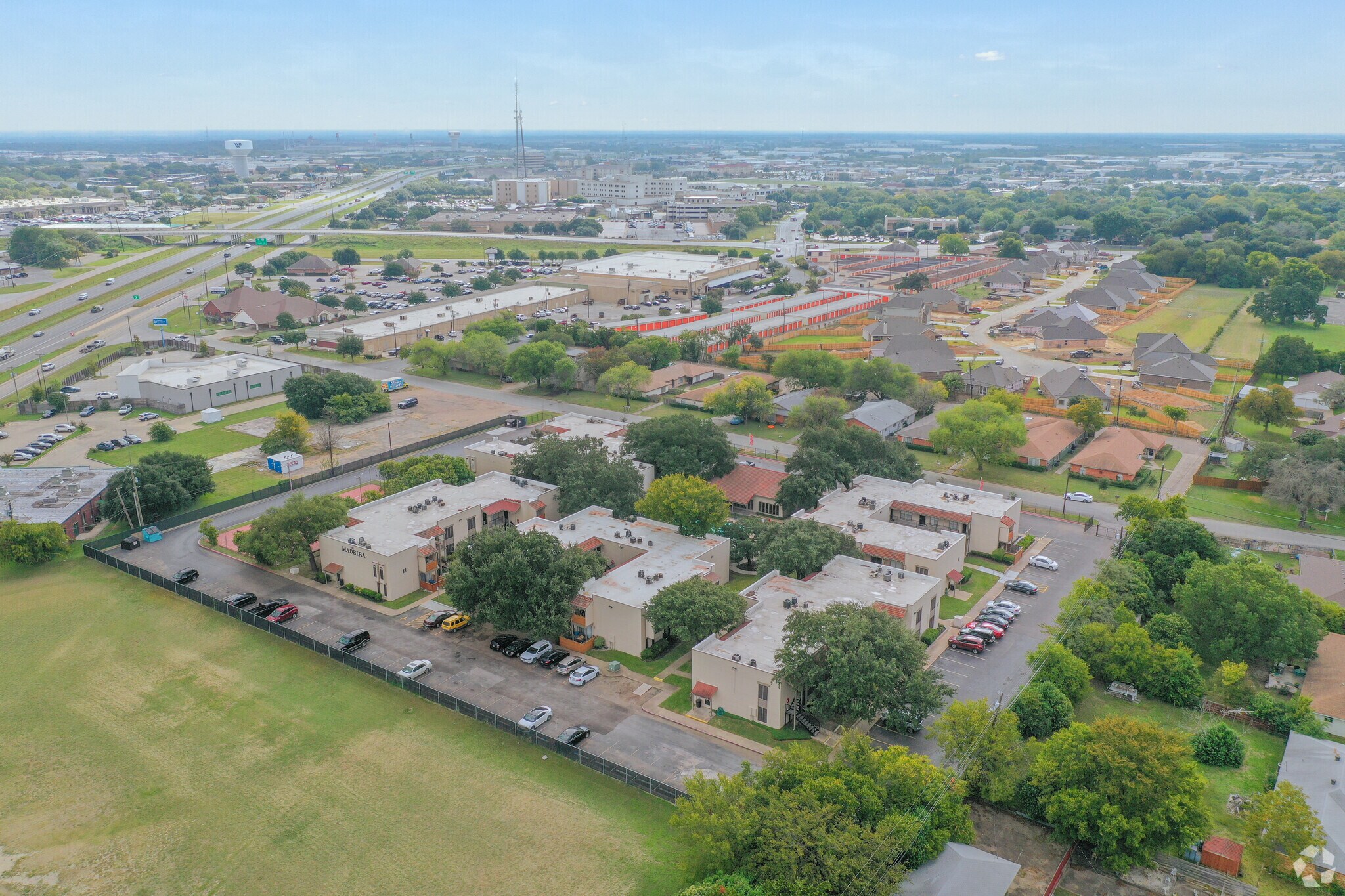 Aerial view of Madeira Apartments in Waco showing gated community and green space. - Madeira Apartments