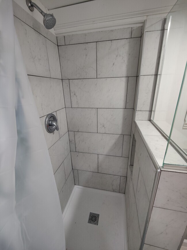 Tiled shower with glass wall gives an open feeling to the bathroom. - 2913 Clover St