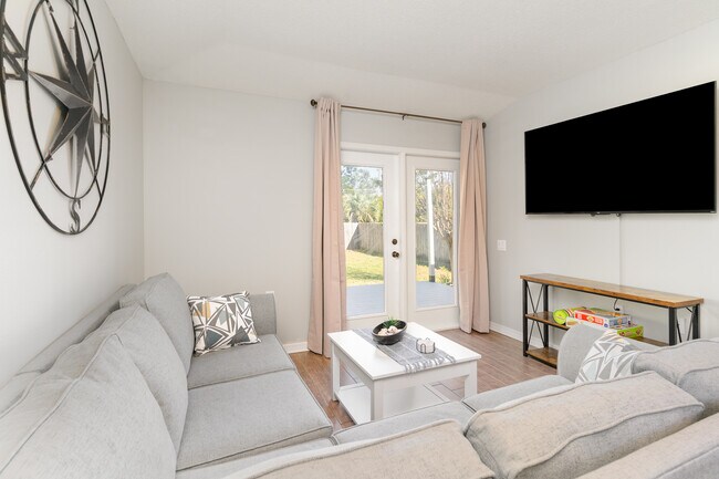 A comfortable couch, a ceiling fan and a 65" Roku TV to relax at the end of the day. - 6464 Starfish Cv