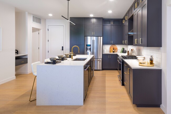 Gourmet kitchens with custom cabinetry, brushed brass hardware and under-cabinet lighting - Modera Cherry Creek