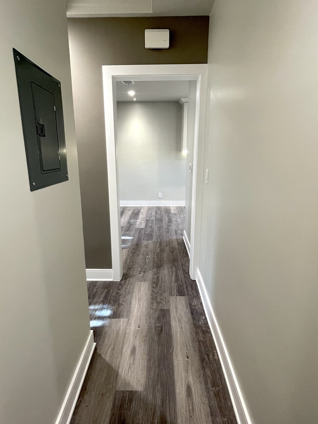 Hallway toward living room with nest thermostat with app access and bedroom door on the left - 3211 W Alameda Ave