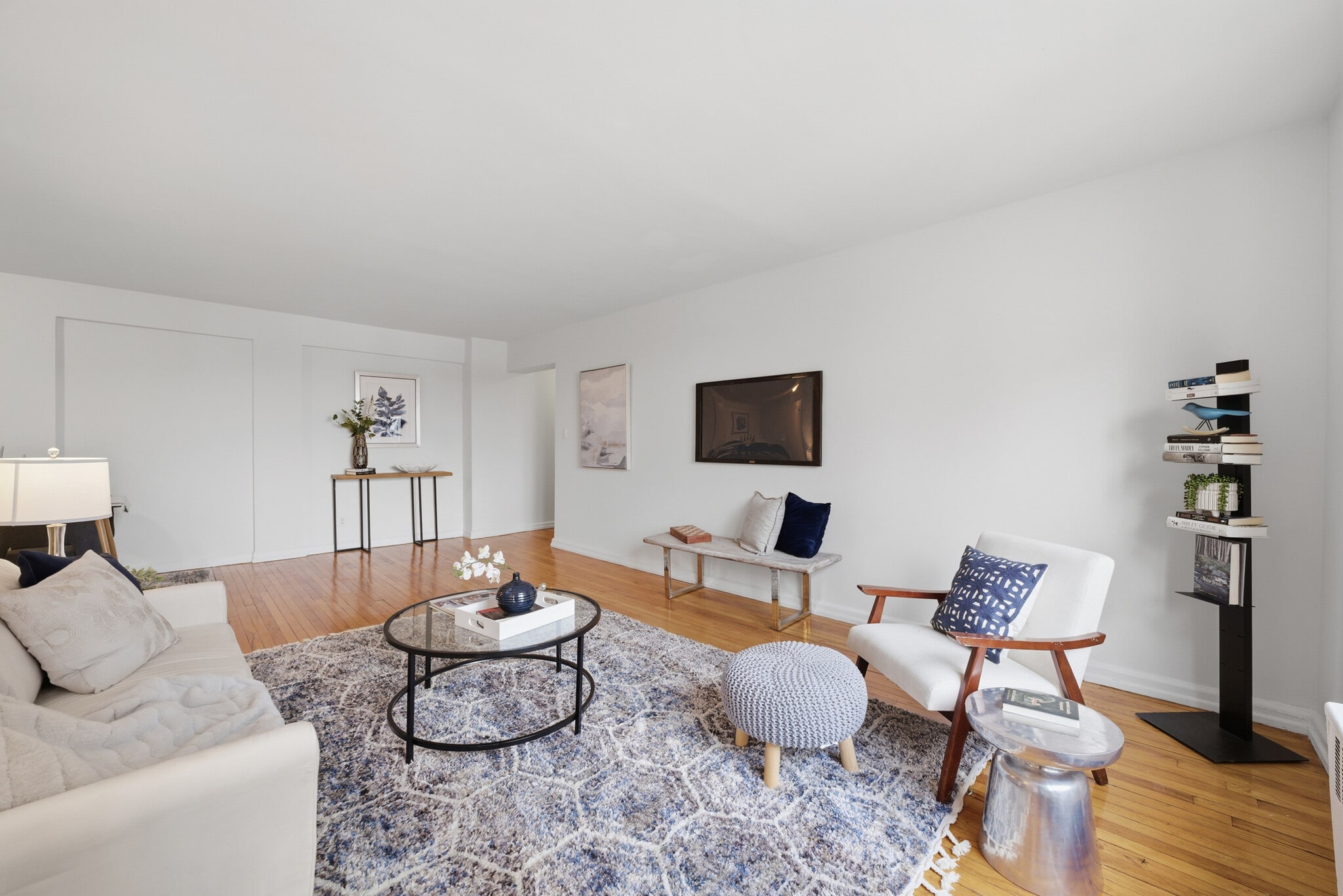 Bright living room with hardwood floors and seamless access to a balcony showcasing the Hudson River - 555 Broadway
