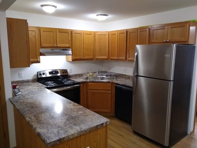 Kitchen with stainless steel appliances and Amish oak cabinets - Crown Pointe Townhomes - Shiloh