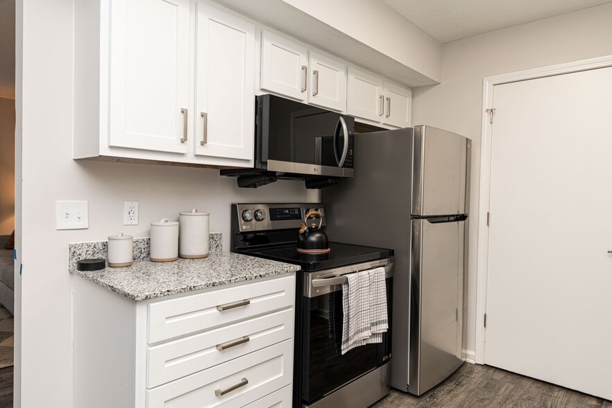 Kitchen with granite counters and stainless appliances - The Wesley Apartment Homes