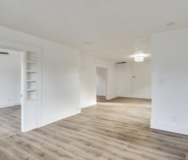 view of the living/dining area, entrance to bedrooms, master bed ft bookcase shelves - 3317 W 41st St