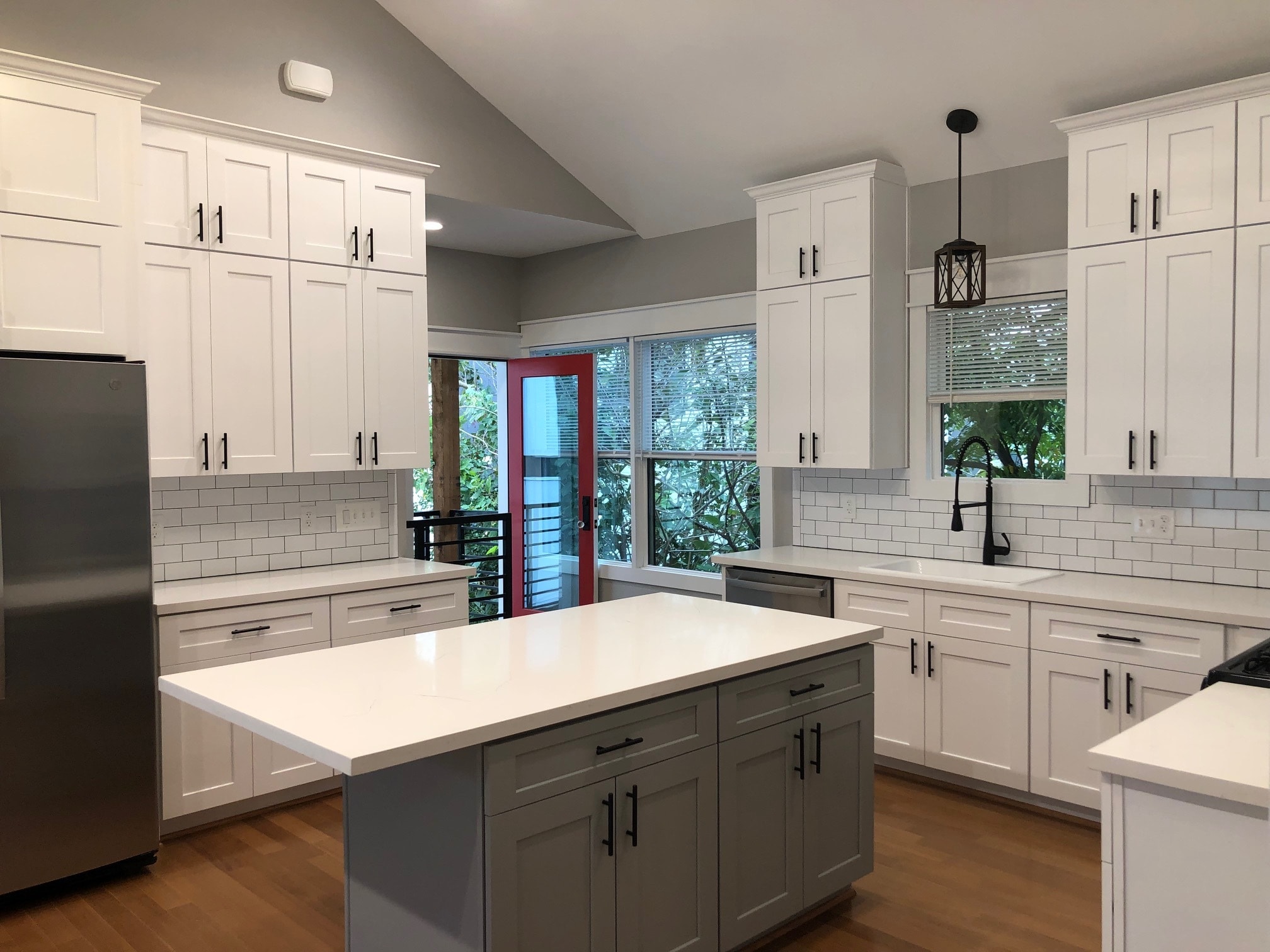 view of kitchen with island seating, entry to private balcony and stairwell leading to front door - 1928 Harold St