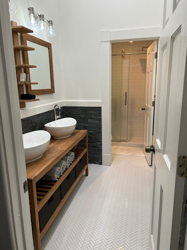 Newly remodeled bathroom with double sink teak vanity and walk in shower. - 20 W Oglethorpe Ave