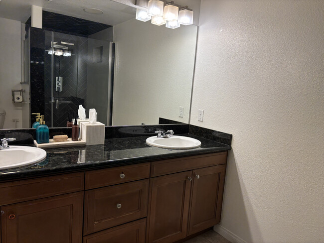 Double vanity primary bathroom with extensive counter space and contemporary lighting - 3740 Santa Rosalia Dr