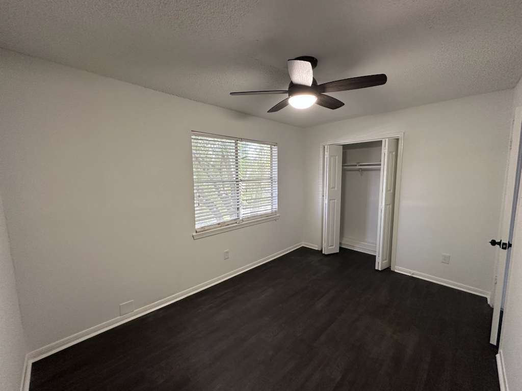Guest Bedroom: Window, brand-new ceiling fan & lighting, and closet - 7700 Creekbend Dr