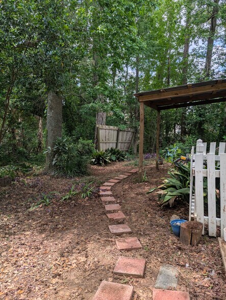 Side yard from front of house, behind fence. - 2228 Sandpiper St