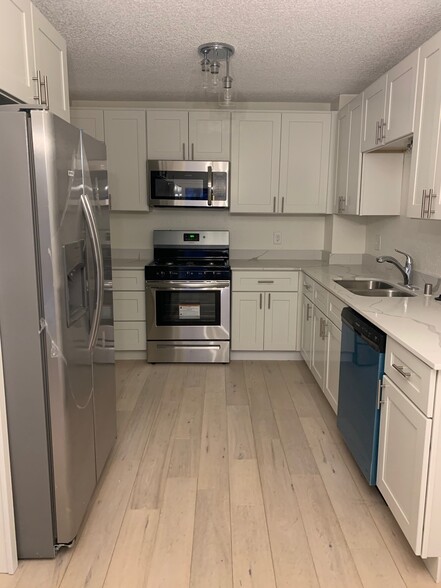 Updated kitchen with new cabinets, appliances and flooring throughout the top floor. - 6224 Magnolia Ln N
