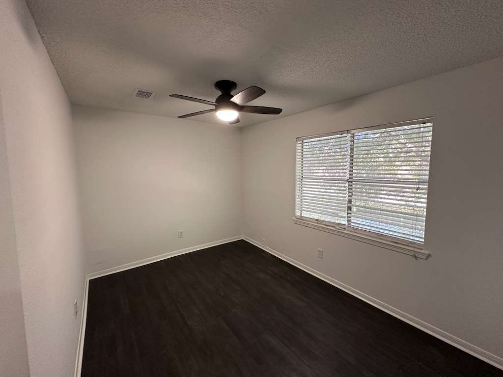 Guest Bedroom: window, brand-new ceiling fan & lighting, and closet. - 7700 Creekbend Dr