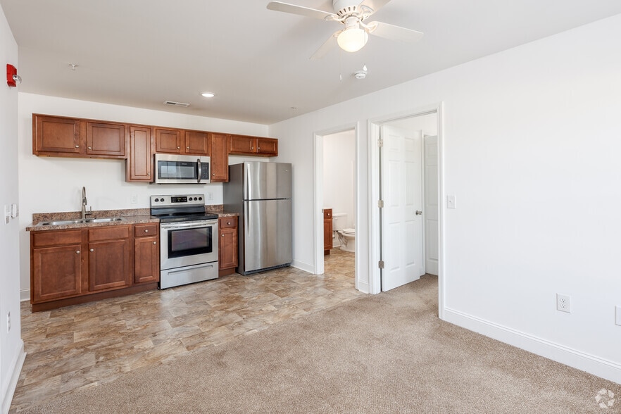 Carpeted living room towards kitchen. - 1200 Hemingway Chapel Rd