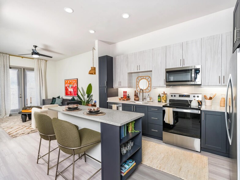 Elevate your culinary skills in our modern kitchen, featuring quartz counter tops, shaker white cabinets with satin pulls, and stainless steel appliances. - Modera EaDo