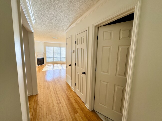 view from entry hall into living room at end, bathroom, coat/linen closet, utility closet at right - 209 14th St. NE #119