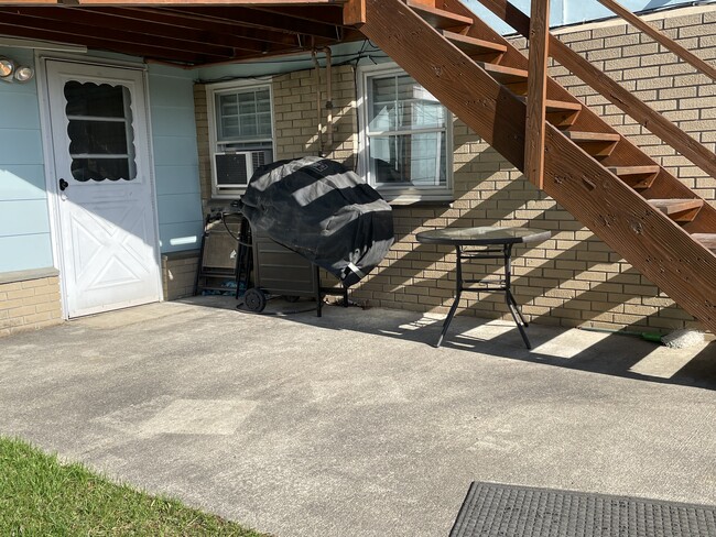 Outdoor patio area with gas grill, and door to on site shared laundry facility - 6030 NY-23