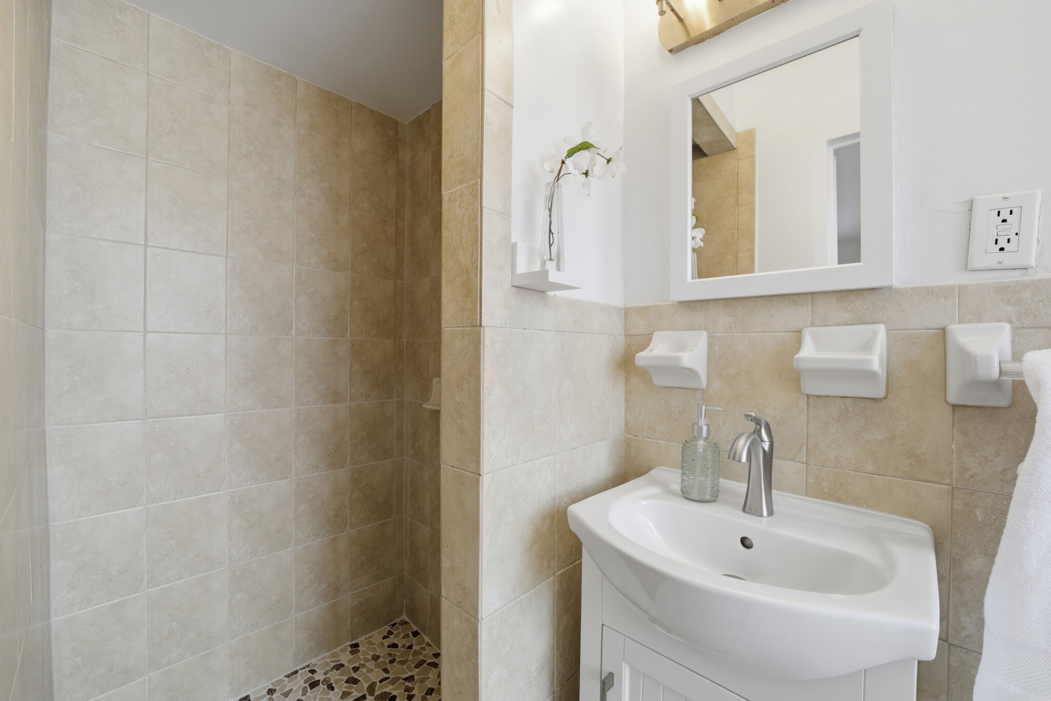 Primary bathroom featuring tiled walls and a stand-in shower. - 555 Broadway