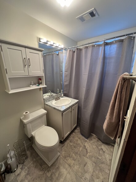 One of two bathrooms, both with tub, shower, combo, and storage - 938 W Newport Ave