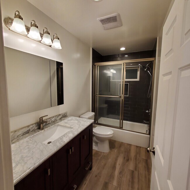 Main full bathroom with Italian Carrera marble top vanity, Kohler double mirrored medicine cabinet. - 5731 Fulton Ave