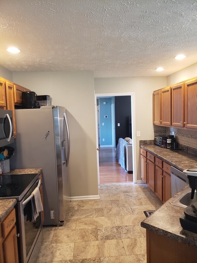 Lots of counter space for food prep, flattop electric range, and stainless steel refrigerator. - 820 Laramie Ct